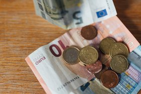 Geldscheine und Münzen liegen auf dem Tisch