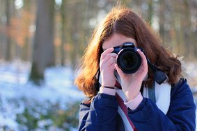 Ein Mädchen fotografiert mit einer Kamera
