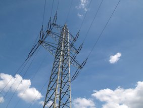 Hochspannungsmast vor blauem Himmel