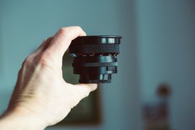 Ein Hand hält ein Kameraobjektiv