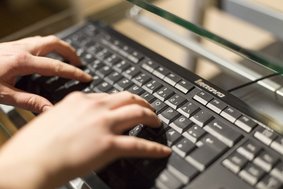 Finger tippen auf schwarzer Tastatur